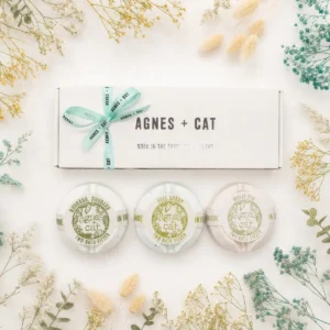 Agnes + Cat presentask med tre badbomber i dofterna rabarber, bär och vitt fikon, omgiven av torkade blommor