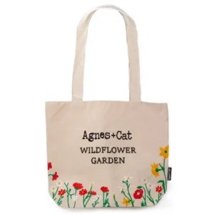 Naturlig bomullsväska med broderade röda blommor och texten Wildflower Garden fram