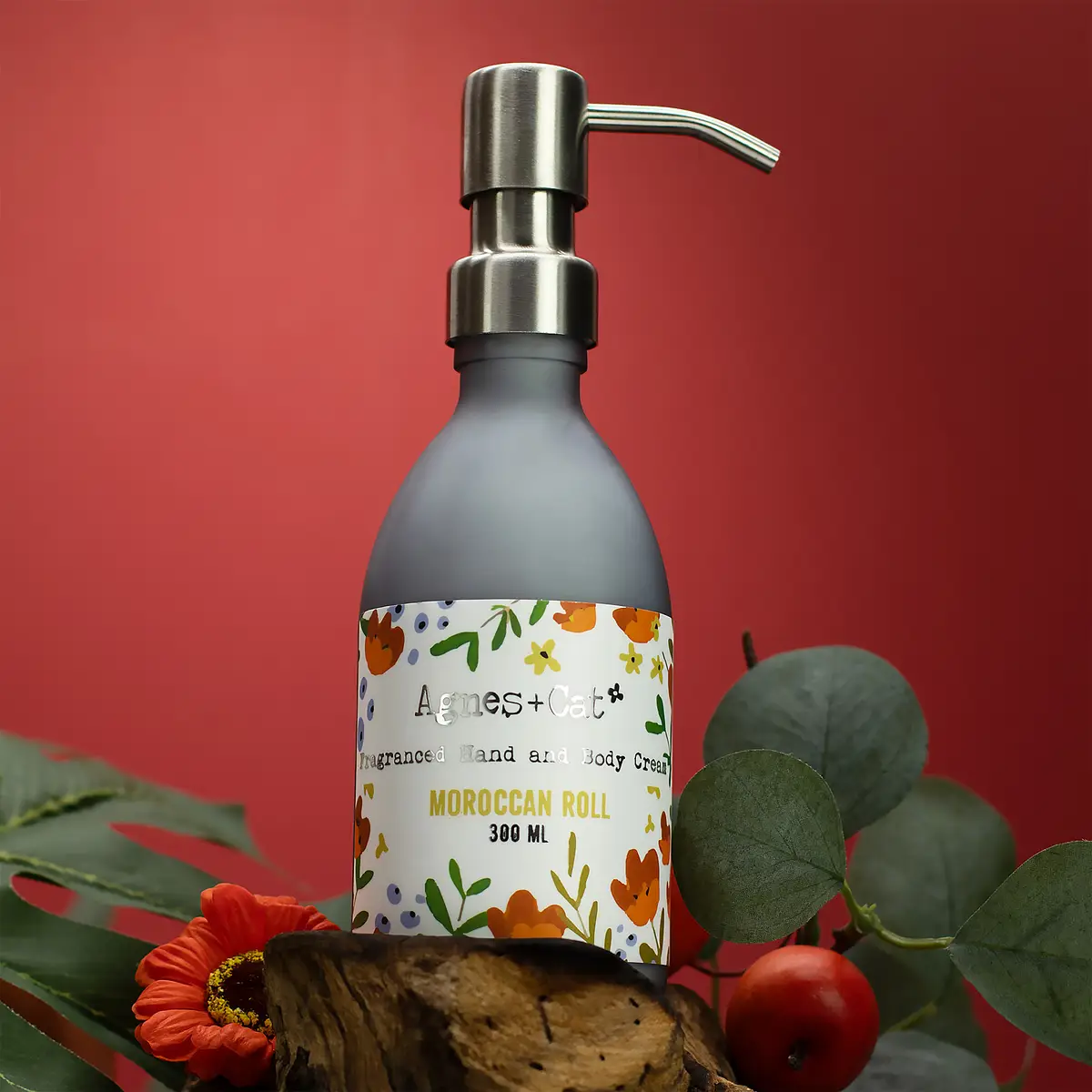 Flaska med Agnes + Cat hand- och kroppskräm Moroccan Roll 300 ml med pump och blommönster