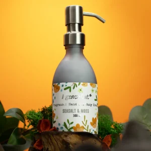 Pumpflaska med Agnes + Cat hand- och kroppskräm Sea Salt & Moss 300 ml mot orange bakgrund