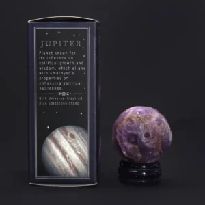 Ametistklot på blått guldkristallstativ bredvid förpackning med Jupiter-motiv