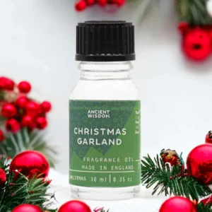 Flaska med Ancient Wisdom doftolja julkrans 10 ml omgiven av juldekorationer med röda kulor och grankvistar
