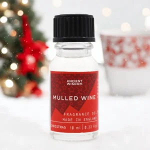 Flaska med Ancient Wisdom doftolja med glöggdoft 10 ml med juldekoration i bakgrunden