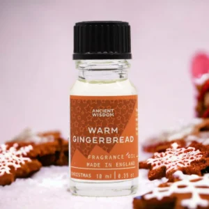 Flaska med Ancient Wisdom doftolja varm pepparkaka 10 ml med pepparkakor i bakgrunden