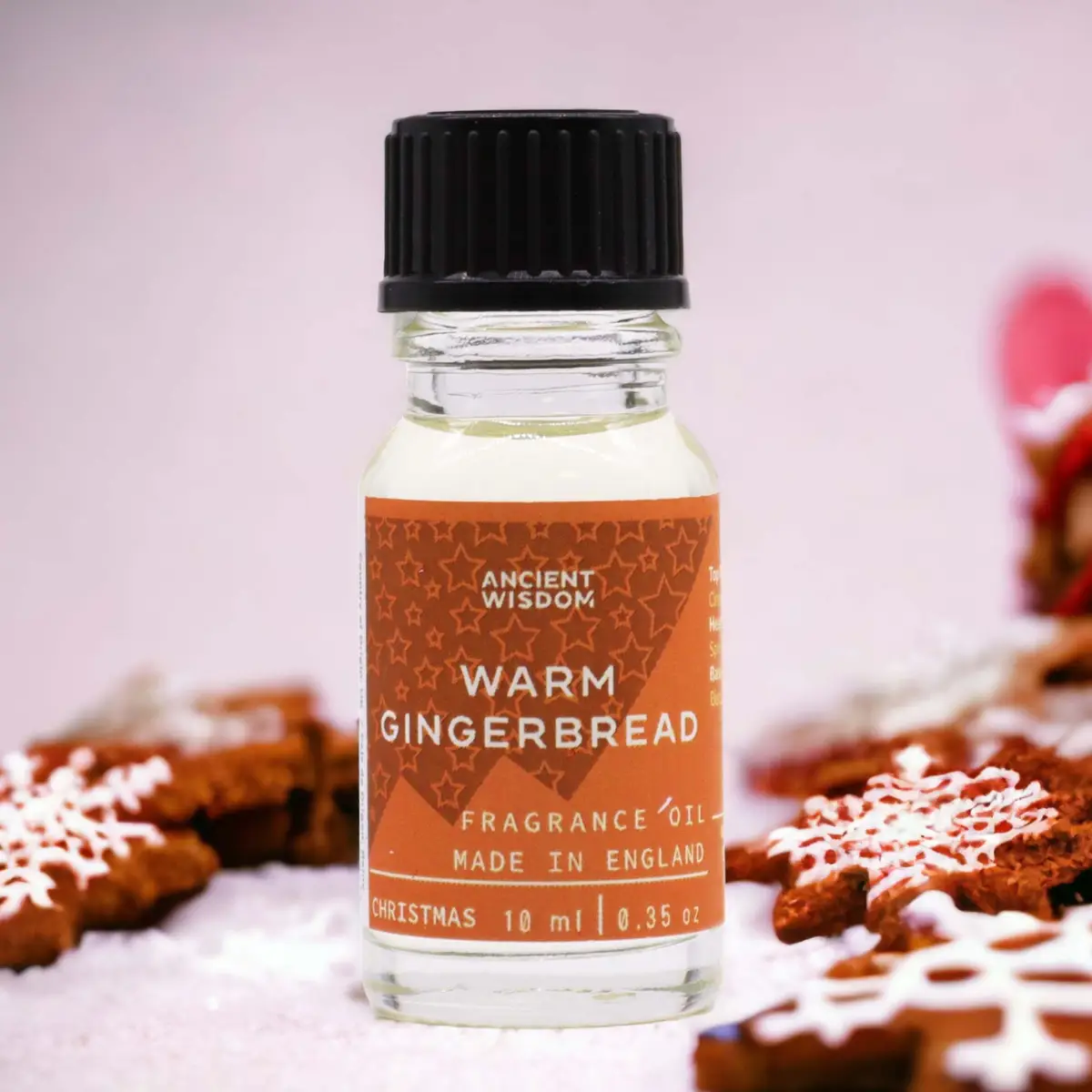 Flaska med Ancient Wisdom doftolja varm pepparkaka 10 ml med pepparkakor i bakgrunden