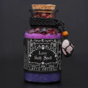 Glasflaska med Ancient Witch badpotion för kärlek, fylld med lila badsalt och rosenblad, med rosenkvartsamulett runt halsen