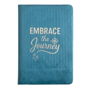 Ljusblå anteckningsbok i sammet med texten Embrace the Journey i silvertryck på omslaget