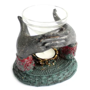 Oljebrännare med antik Buddha och händer som håller en glas-skål