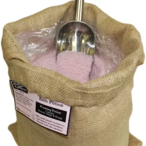 Jutesäck med rosa aromaterapeutiskt badsalt och metallskopa