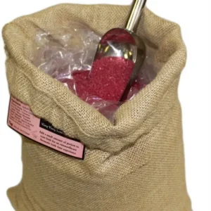 Jutesäck med rött aromaterapeutiskt badsalt och skopa