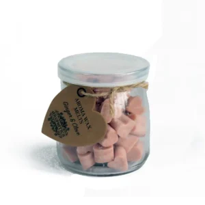 Glasburk med hjärtformade rosa sojavaxsmältor och etikett med text Aroma Wax Melts Ginger & Clove