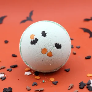 Rund badbomb med dekorativa Halloweenfigurer på orange bakgrund