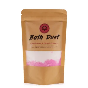 Påse med badpulver i vitt och rosa, märkta med texten Bath Dust Raspberry & Black Pepper