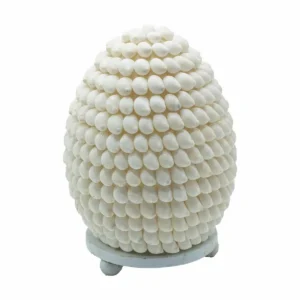Oval lampa täckt med vita naturliga snäckskal på vit bakgrund