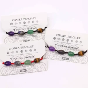 Flera chakra-armband i tråd med färgglada ädelstenspärlor på vit bakgrund