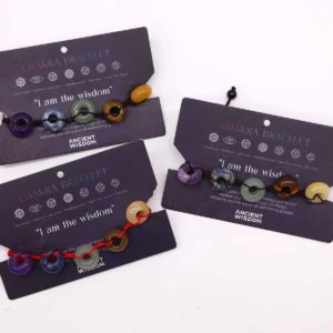 Chakra-armband i tråd med kulor av olika ädelstenar på förpackning