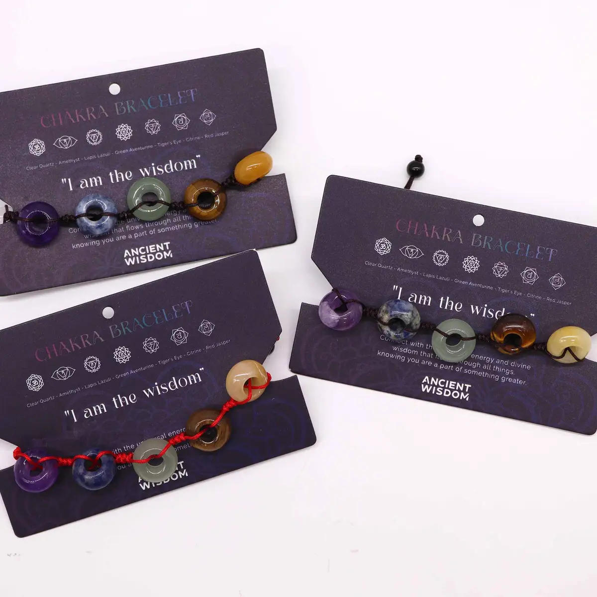 Chakra-armband i tråd med kulor av olika ädelstenar på förpackning