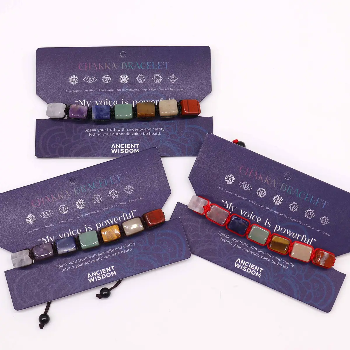 Flera chakra-armband i tråd med färgglada slipade stenar på blå kort