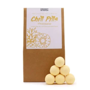 Brunt presentpaket med Chill Pills badbomber i Pinacolada-doft staplade framför