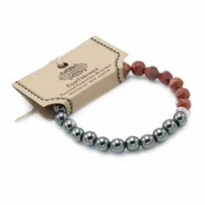Fasetterat armband med röda jaspis- och magnetpärlor på vit bakgrund