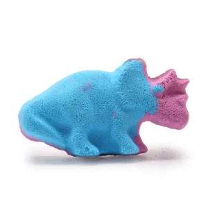Blå och rosa formad badbomb i dinosaurieform på vit bakgrund