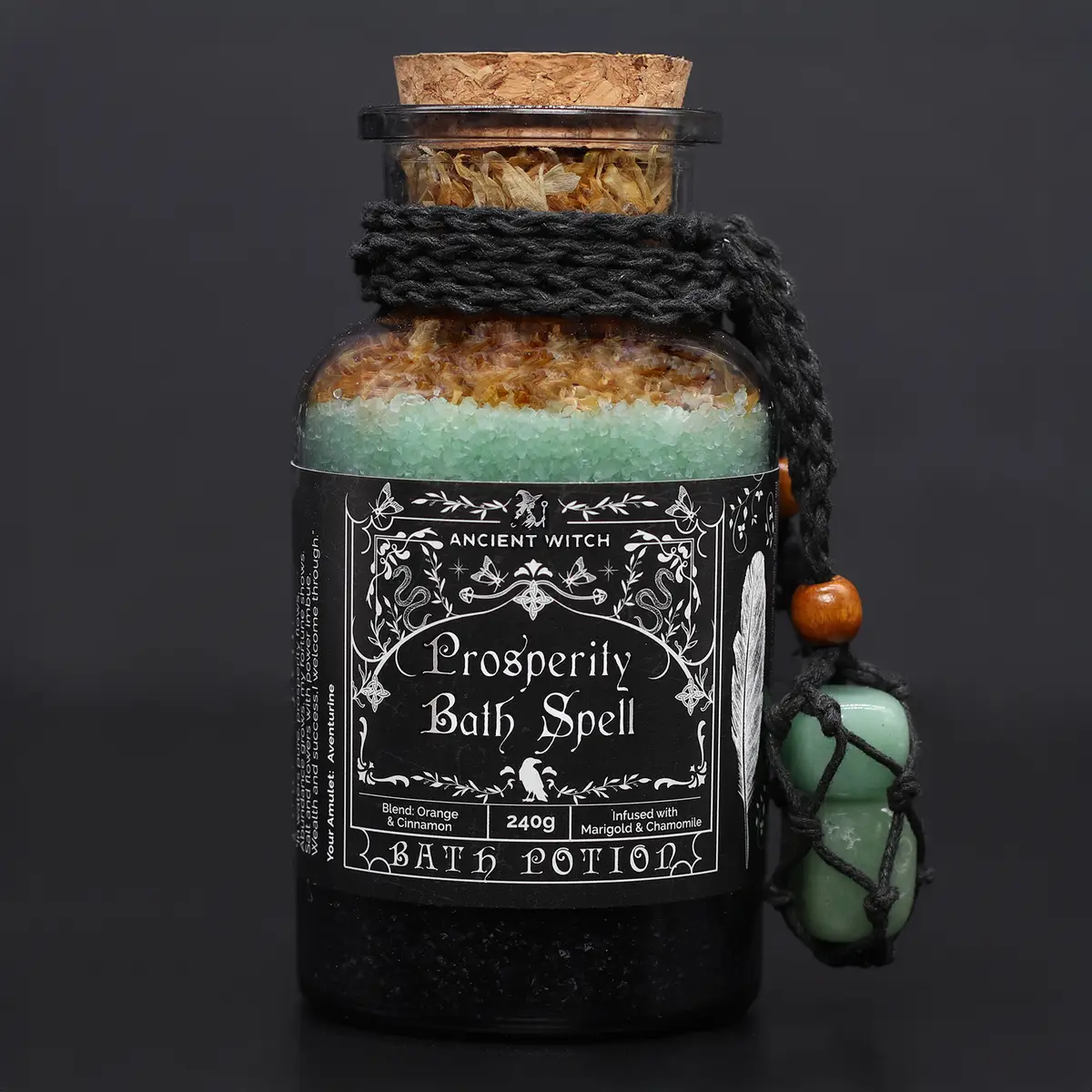 Glasflaska med badpotion och badsalt prydd med svart snöre och aventurinkristall amulett