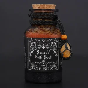 Glasflaska med badpotion och citrinkristall amulett mot mörk bakgrund
