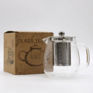 Glaskanna med infuser i rostfritt stål och kartong i bakgrunden