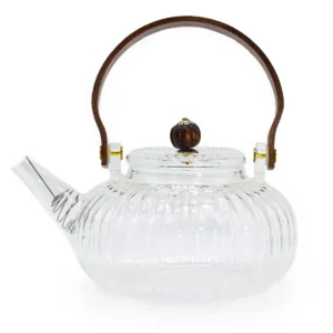 Klar glaskanna med räfflad yta och trähandtag, infuser synlig i pipen