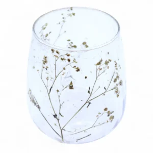 Glasljusstake med torkade blommor inbäddade i klart glas