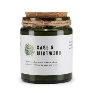 Grönt glasljus med korklock och etikett med texten Sage & Mintwood