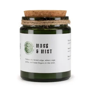 Grönt doftljus i glasburk med korklock och vit etikett med text Moss & Mist