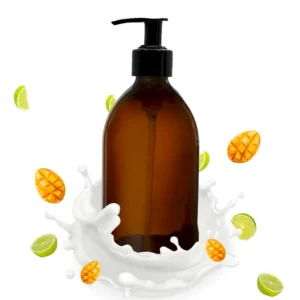 Brun pumpflaska med hand- och kroppslotion omgiven av mango- och limeskivor