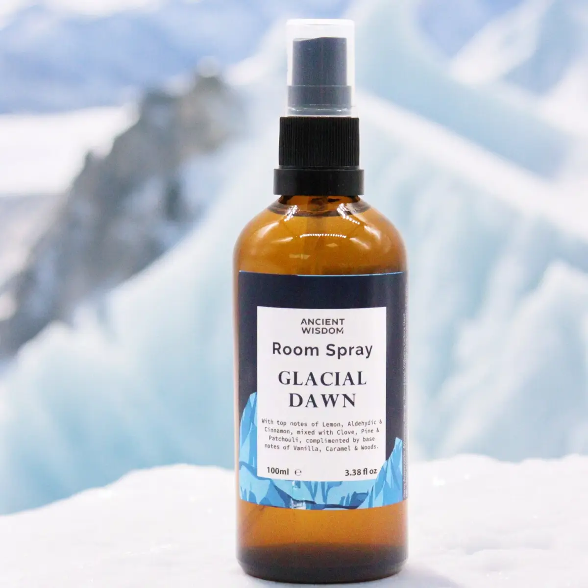 Brun glasflaska med rumsspray Glacial Dawn mot isigt bakgrund