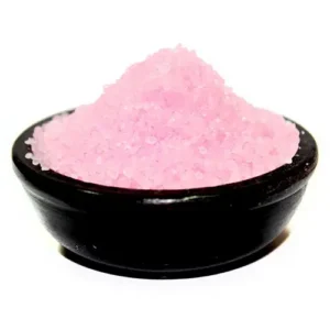 Rosa doftande saltgranulat i svart skål för oljebrännare