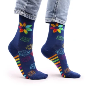 Mörkblå bambustrumpor med färgglatt chakramönster och regnbågsfärgade ränder på sidan, på fötter med jeans