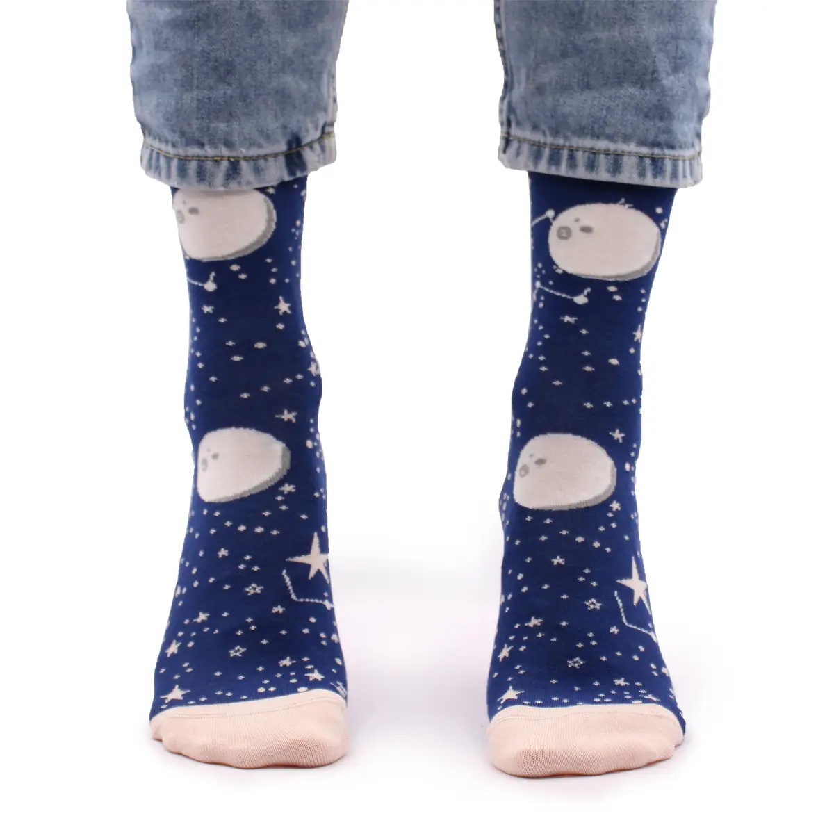 Person som bär blåa strumpor med månmönster och stjärnor, uppvikta jeans