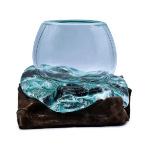 Mini skål i klart smält glas på en bas av mörkt naturligt trä