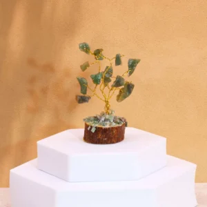 Miniatyrträd med gröna aventurin-ädelstenar på träbas mot beige bakgrund