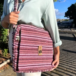 Person som bär en rosa mönstrad mjuk laptopväska Banjara med justerbar axelrem