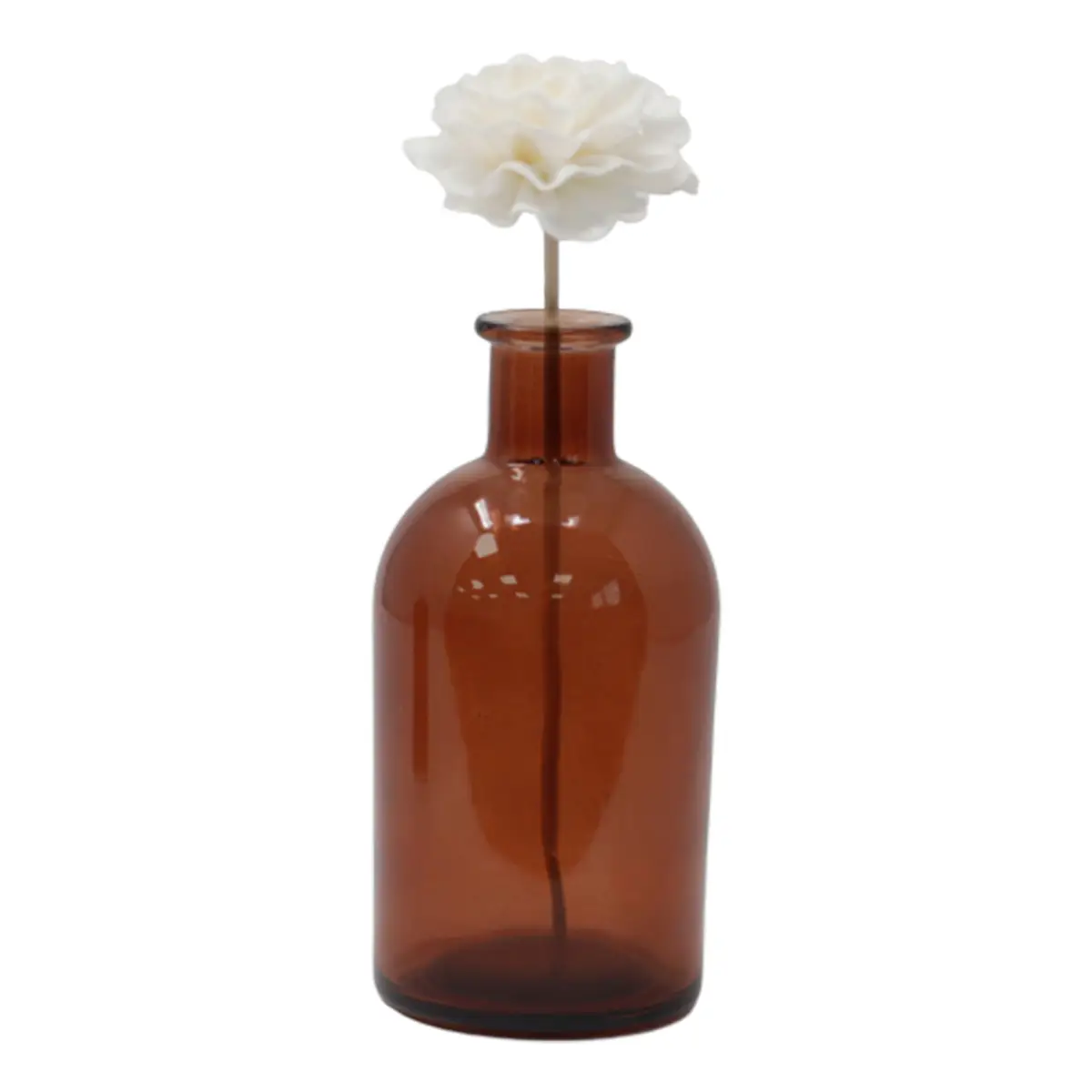 Vit nejlikaliknande doftblomma på brun glasflaska med vasspinne