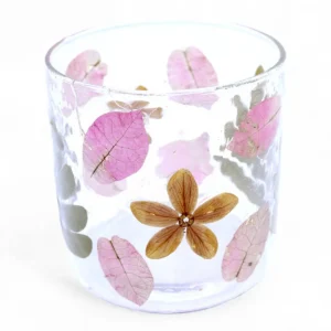 Glasljusstake med pressade rosa och bruna blommor och blad i återvunnet glas