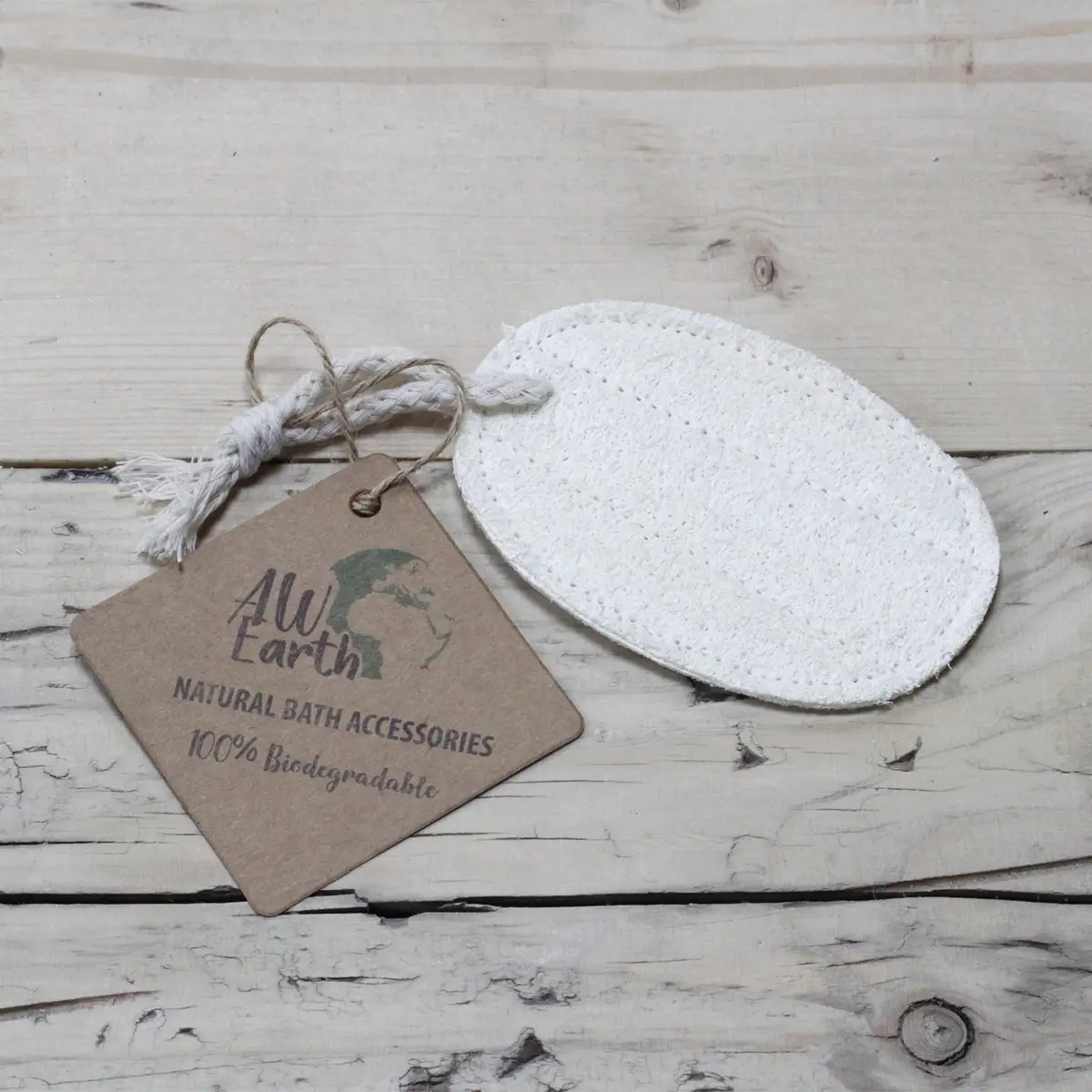 Oval naturlig loofah-kroppsskrubb med snöre och etikett på träyta
