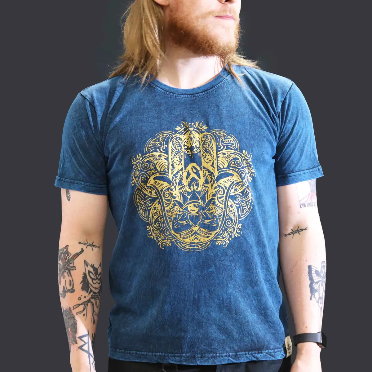 Man i blå stonewashed bomulls-T-shirt med gult Hamsa-tryck