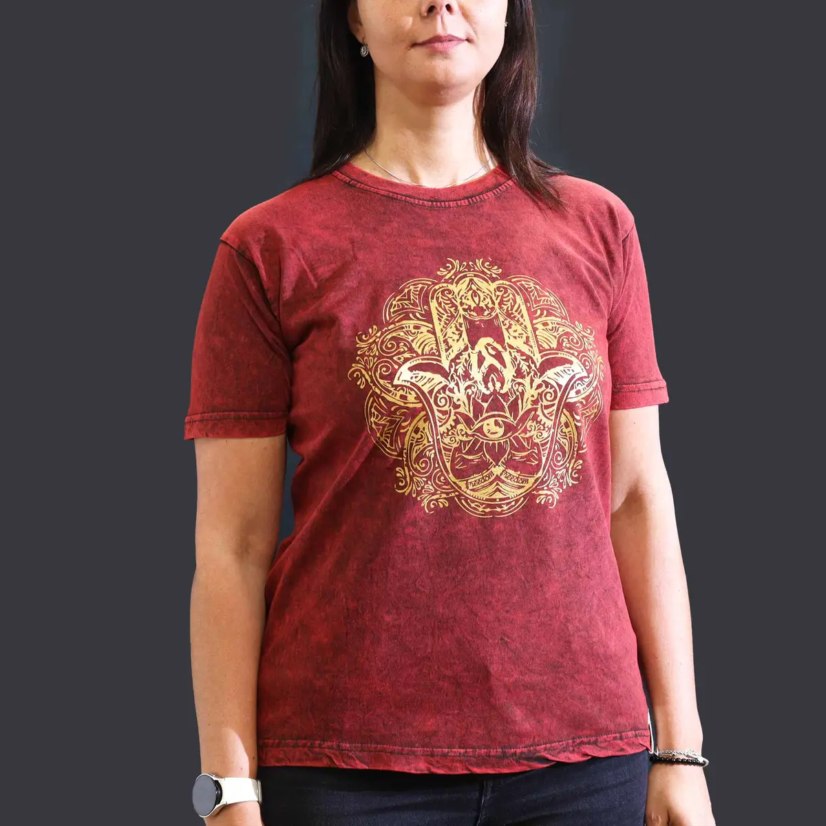 Vinröd stonewashed bomulls-T-shirt med gult Hamsa-tryck på bröstet, modell bär plagget
