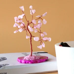 Önsketräd med rosenkvartsstenar på rosa agatbas placerat på bok