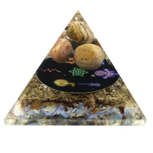 Orgonitpyramid med metallspån och stenar i transparent harts
