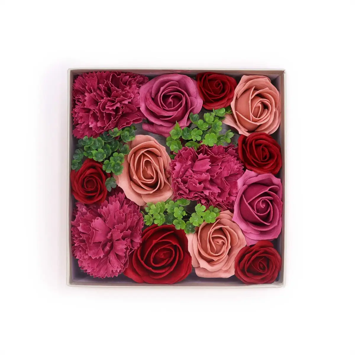Presentask med tvåltrosor i olika nyanser av rött och rosa med gröna blad