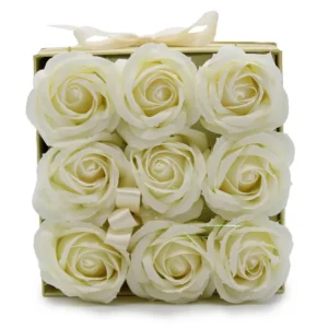 Nio krämfärgade tvålblommor formade som rosor i en fyrkantig ask med rosett