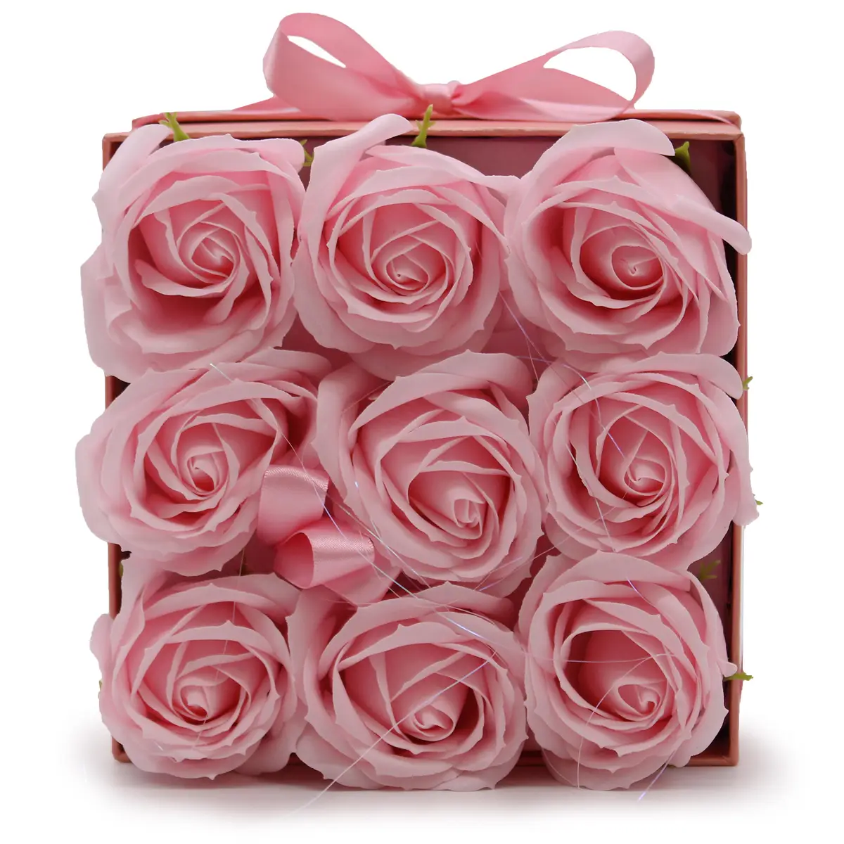 Nio rosa tvålblommor arrangerade i en fyrkantig rosa presentask med rosett